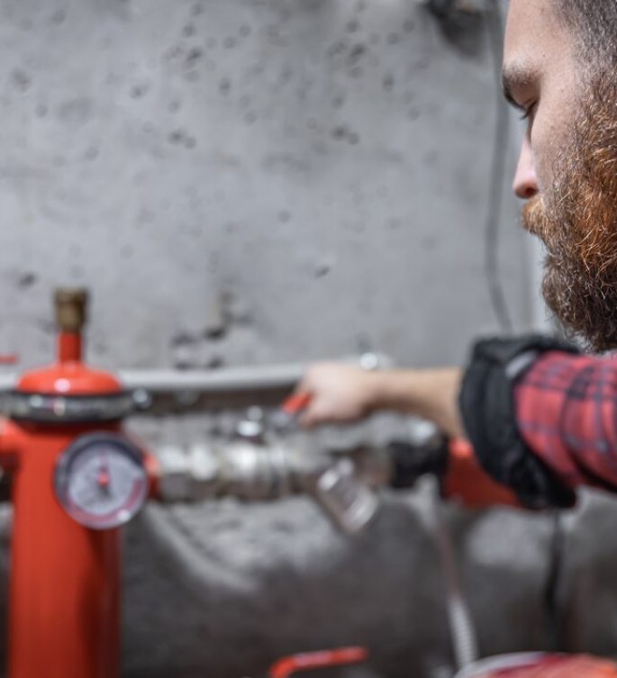 man looks faucet pipes valve pressure meter